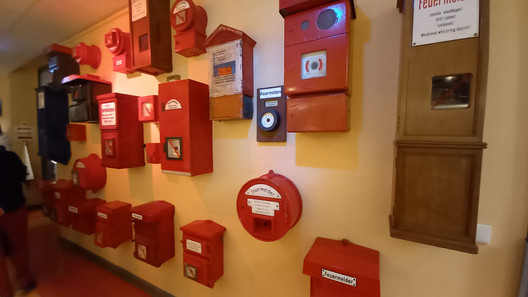 an einer Wand sind diverse rote Feuermelder angebracht