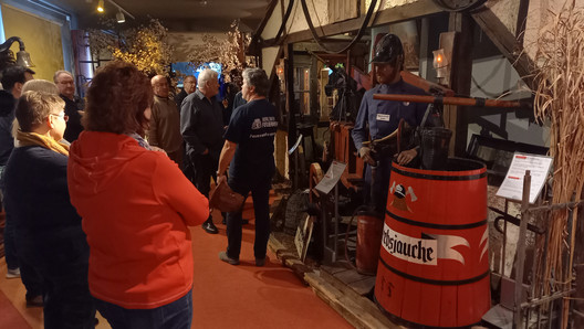 Mehrere Personen im Feuerwehrmuseum, denen eine Übung erklärt wird